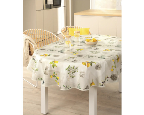 Szene mit einem Esstisch mit runder Tischdecke, dekoriert mit Zitronenmotiven in einer hellen Küche.
