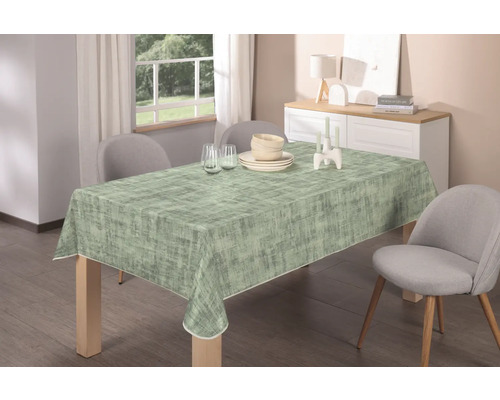 Esstisch mit gemusterter Tischdecke, Geschirr und Dekoration in einem hellen Esszimmer.