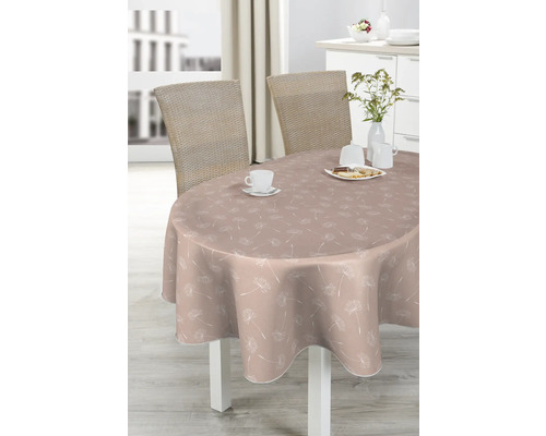 Ovaler Tisch mit Tischdecke mit Pusteblumenmuster, gedeckt mit Geschirr und Gebäck.