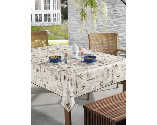 Gedeckter Tisch mit Kaffeemuster-Tischdecke im Freien.