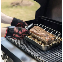 Eine Person misst die Temperatur eines Fleischstücks auf einem Grill mit einem digitalen Thermometer und Hitzeschutzhandschuhen.