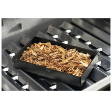 Räucherbox mit Räucherholz auf einem Grillrost