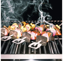 Gemüsespieße mit Haltern auf einem Grill mit Rauchentwicklung