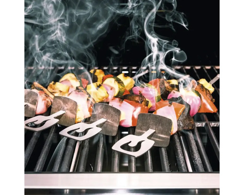 Gemüsespieße mit Haltern auf einem Grill mit Rauchentwicklung