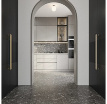 Blick durch einen Bogen auf eine moderne Küche mit grauer Arbeitsplatte und Fliesenboden