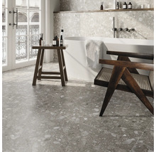 Badezimmer mit Badewanne, Hocker und Fliesen im Terrazzo-Stil