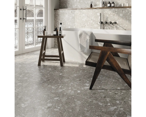 Badezimmer mit Badewanne, Hocker und Fliesen im Terrazzo-Stil