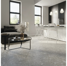 Modernes Wohnzimmer mit Sofa, Tisch und Bodenfliesen in Steinoptik