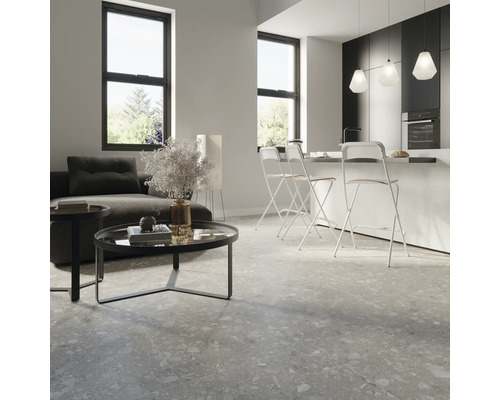 Modernes Wohnzimmer mit Sofa, Tisch und Bodenfliesen in Steinoptik