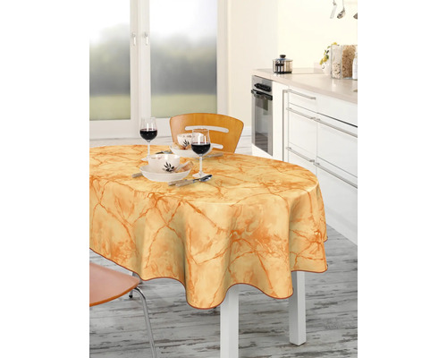 Esstisch mit Wachstuchdecke und Geschirr in einer hellen Küche.