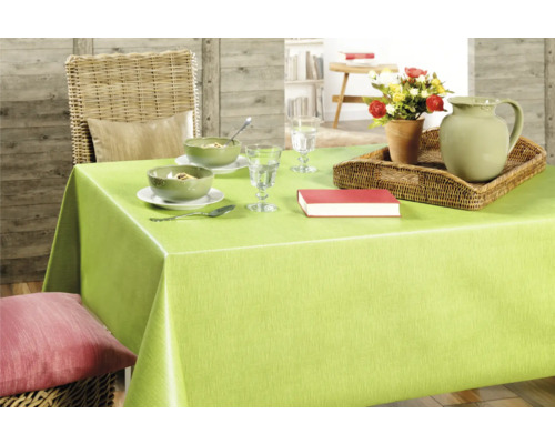 Gedeckter Esstisch mit grüner Tischdecke, Geschirr, Karaffe, Blumen und Buch