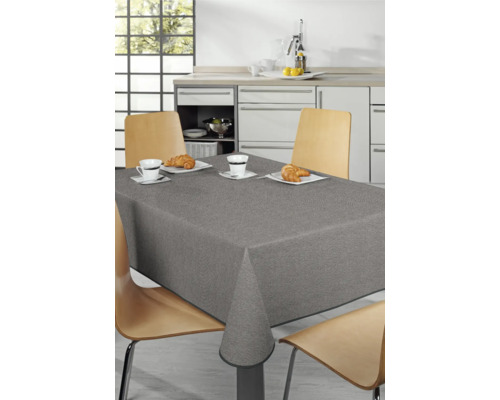 Esstisch mit grauer Tischdecke und Geschirr in einer hellen Küche.