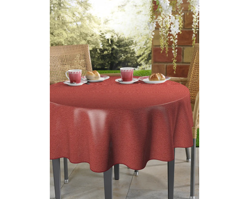 Runder Tisch mit roter Tischdecke, Gedeck mit Tassen und Gebäck im Garten