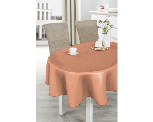 Ovaler Tisch mit pfirsichfarbener Tischdecke, gedeckt mit Geschirr