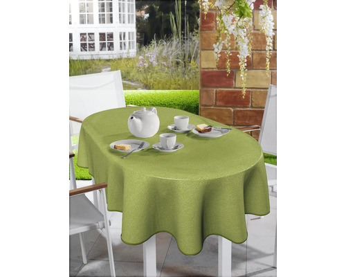 Gedeckter Gartentisch mit hellgrüner, ovaler Tischdecke, Geschirr und Kuchen