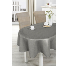 Esstisch mit grauer Tischdecke, Geschirr und Rattanstühlen in hellem Raum.