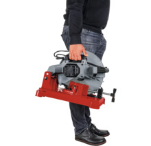 Person hält eine Metallsäge mit rotem Sockel in der Hand.