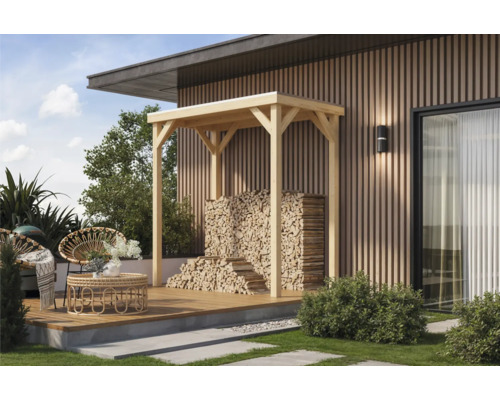 Terrasse mit Holzunterstand und gestapeltem Brennholz vor einer modernen Hausfassade