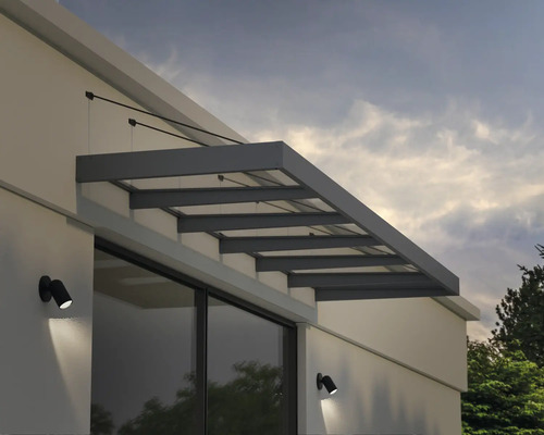 Modernes Haustürvordach aus Glas und grauem Metall mit Zugstangen an einer weißen Fassade über einem Fenster montiert.