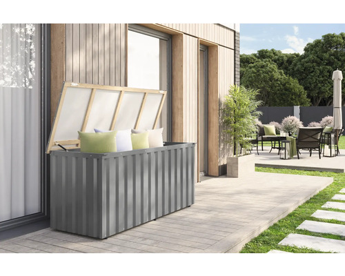 Graue Gartenbox mit geöffnetem Deckel und Kissen auf einer Terrasse