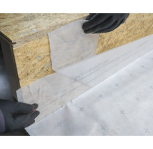 Anbringung einer Bauplane an einer Holzkonstruktion zum Schutz.