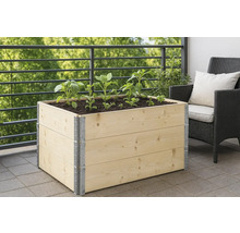 Hochbeet aus Holz mit Pflanzen auf einem Balkon.