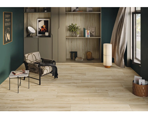 Wohnraum mit Holzbodenfliesen, Sessel, Tisch und Dekoration