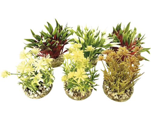 Drei künstliche Pflanzen in Töpfen mit Kieselsteinen