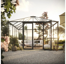 Geräumiges Gewächshaus mit Sitzgelegenheiten und Pflanzen in einem Garten.