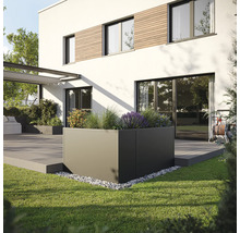 Quadratischer Pflanzkübel im Garten vor einem modernen Haus.