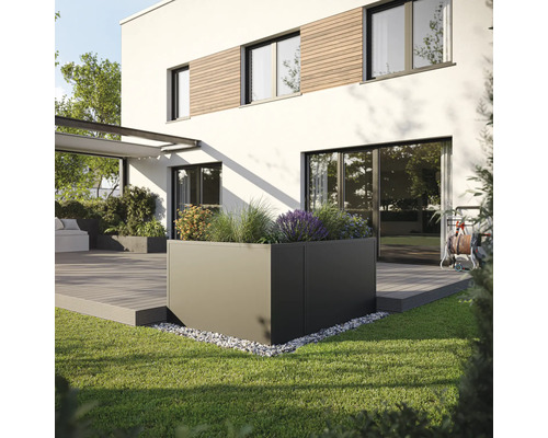 Quadratischer Pflanzkübel im Garten vor einem modernen Haus.