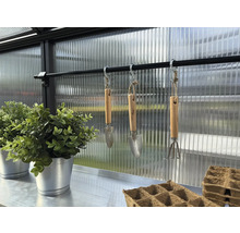 Innenansicht Gewächshaus mit Gartenwerkzeug, Anzuchttöpfen und Pflanzen