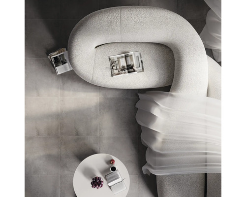 Ansicht von oben: Wohnzimmer mit Sofa, Tisch, Getränken, Obst und Zeitschriften auf Fliesenboden.