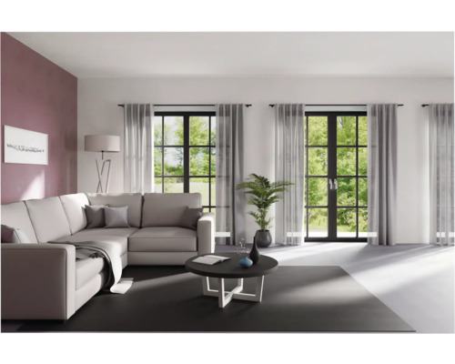 Wohnzimmer mit Ecksofa, Couchtisch und Vorhängen vor Fenstern