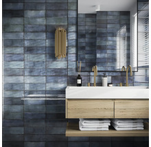 Badezimmer mit Waschbecken, Spiegel und Wandfliesen