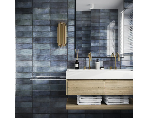 Badezimmer mit Waschbecken, Spiegel und Wandfliesen