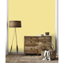 Wohnzimmer mit Kommode, Stehlampe, Körben und gelber Streifentapete.