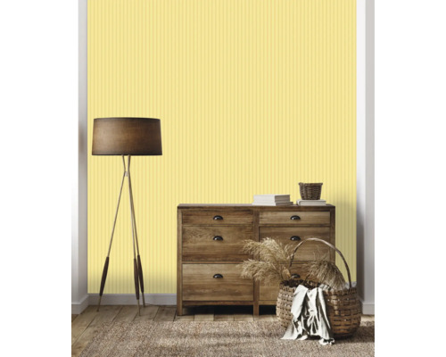 Wohnzimmer mit Kommode, Stehlampe, Körben und gelber Streifentapete.