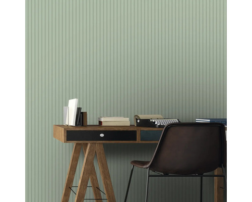Szene mit Schreibtisch, Stuhl, Büchern und Schreibmaschine vor einer Wand mit Streifenmuster
