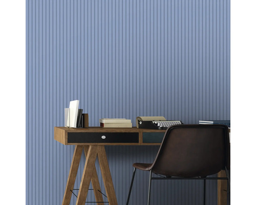 Arbeitszimmer mit Schreibtisch, Büchern, Schreibmaschine und Stuhl vor einer Wand mit vertikalem Streifenmuster