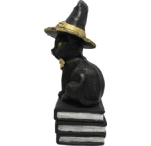 Dekorative schwarze Katzenfigur mit Hexenhut auf Bücherstapel