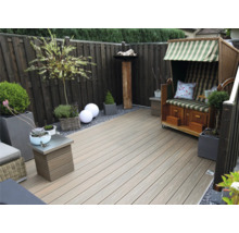 Gestalteter Gartenbereich mit Holzterrasse, Strandkorb und Bepflanzung