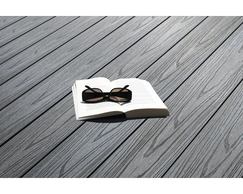 Buch und Sonnenbrille auf grauen Terrassendielen