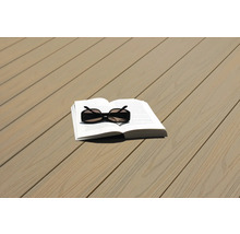 Buch und Sonnenbrille auf Terrassendielen