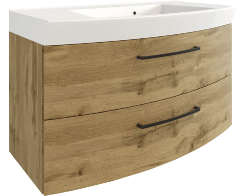 Waschbeckenunterschrank mit Waschbecken, Eiche-Optik, zwei Laden mit schwarzen Griffen und geschwungener Front.