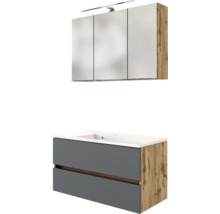 Badezimmermöbel-Set bestehend aus Waschtischunterschrank in Grau und Eichenoptik mit weißem Waschbecken und dreitürigem Spiegelschrank mit LED-Leuchte.