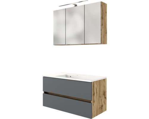 Badezimmermöbel-Set bestehend aus Waschtischunterschrank in Grau und Eichenoptik mit weißem Waschbecken und dreitürigem Spiegelschrank mit LED-Leuchte.