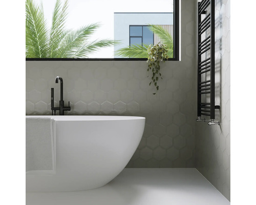 Badezimmer mit Badewanne, Handtuchwärmer und sechseckigen Wandfliesen