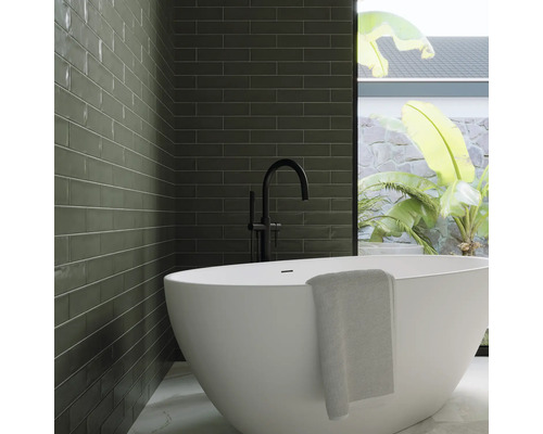 Modernes Badezimmer mit grünen Fliesen, freistehender Badewanne und schwarzer Armatur