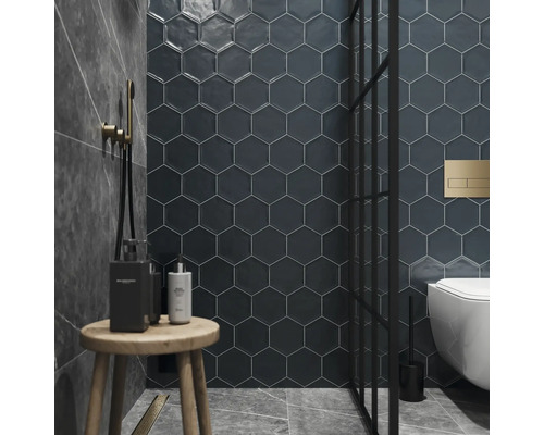 Badezimmer mit sechseckigen Wandfliesen, Dusche, Toilette und Holzhocker